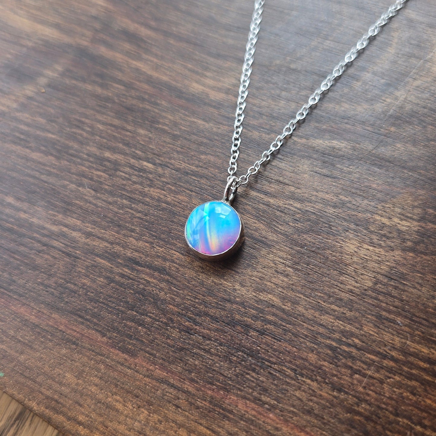 Necklace with an opal pendant on a wooden surface