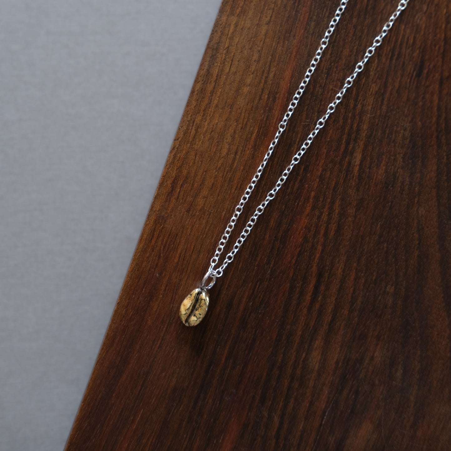 A golden coffee bean sitting on a wooden board