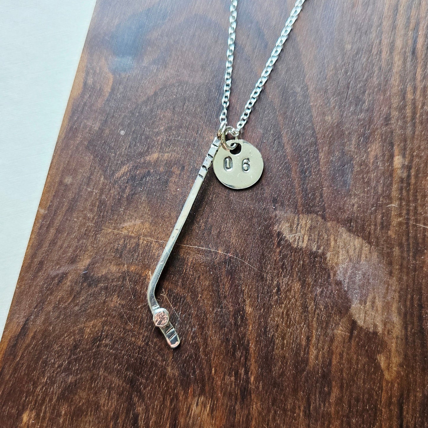 a sterling silver ice hockey necklace with jersey number tag