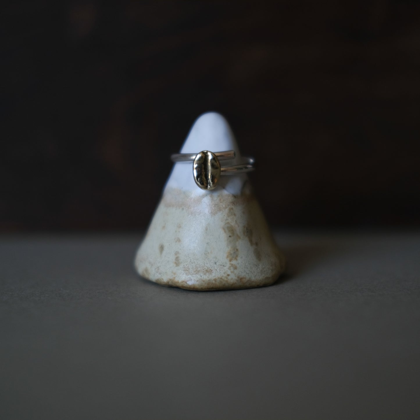 a golden ring sitting on a handmade ring stand