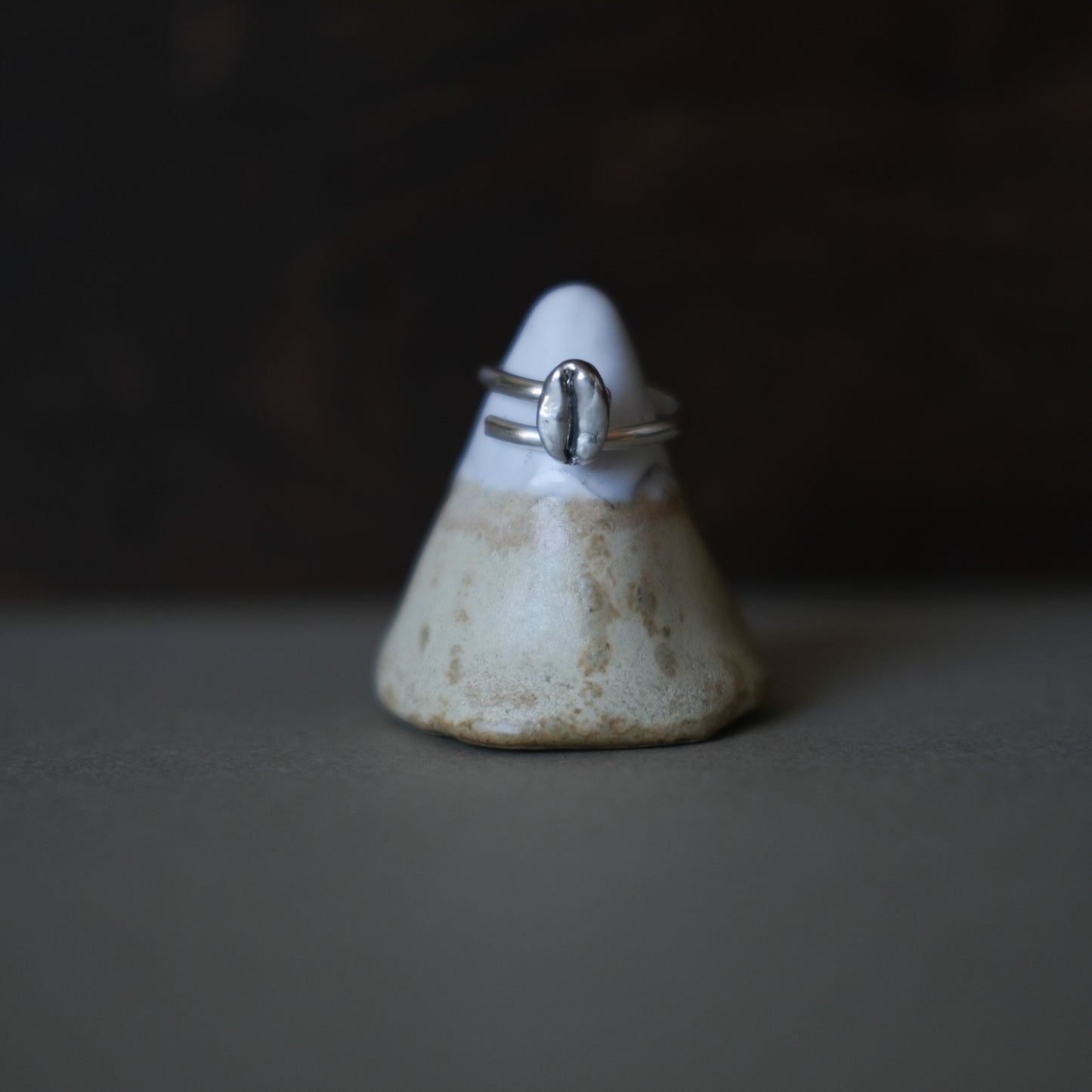 a sterling silver ring sitting on a handmade ring stand