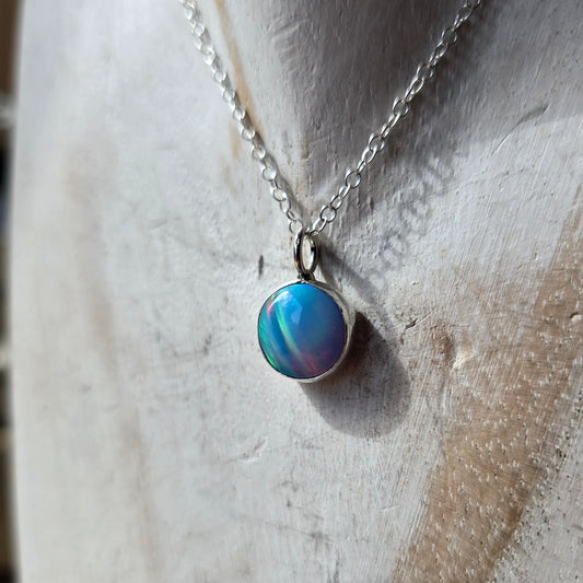 Close-up of a blue gemstone on a white wooden bust