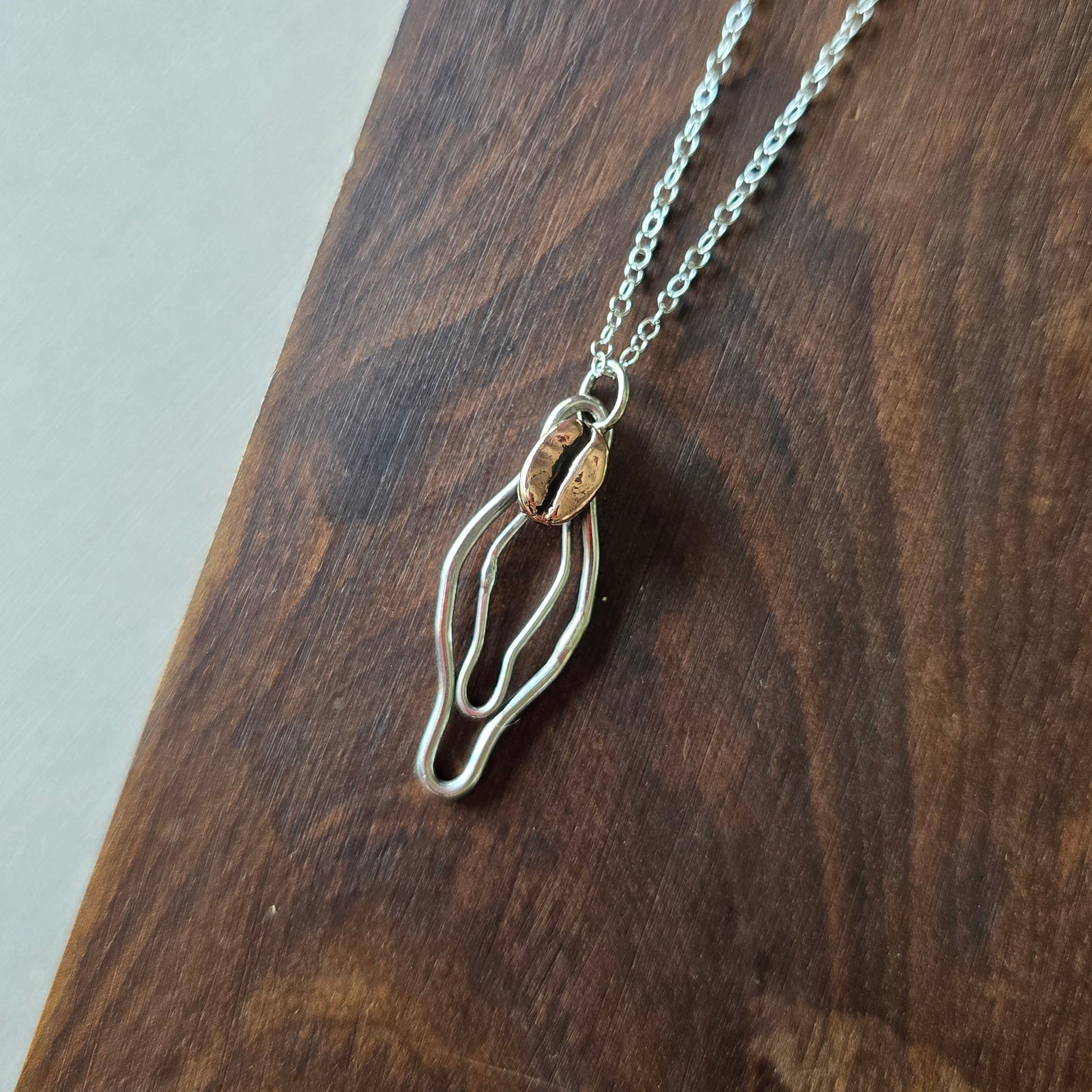 sterling silver vulva necklace with a red bronze coffee bean 
